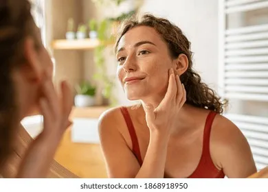 beauty-girl-looking-mirror-while-260nw-1868918950 Lựa chọn đúng thành phần dưỡng ẩm giúp làn da luôn rạng rỡ và khỏe mạnh