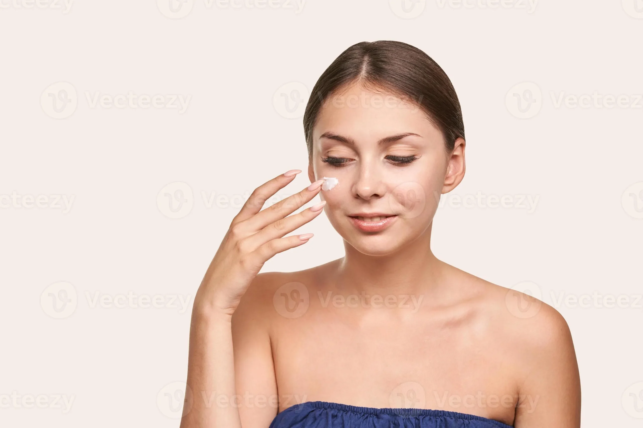 young-caucasian-female-applying-moisturizing-cream-to-face-with-gentle-care-photo-scaled-1 Phục hồi làn da bằng cách tối giản quy trình và ưu tiên các hoạt chất làm dịu